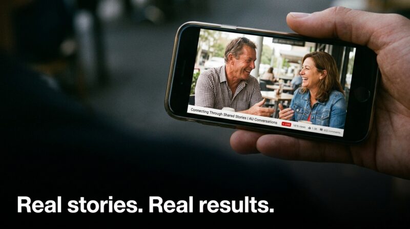 Phone displaying video of two people conversing outdoors with text overlay.